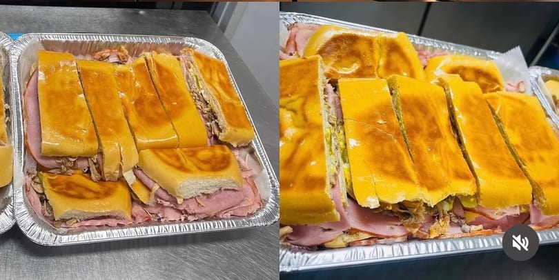 Two foil trays filled with sliced Cuban sandwiches, revealing ham, pork, cheese, and pickles.
